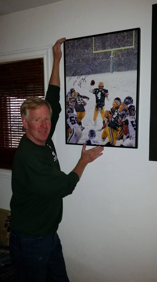 Pete displaying the framed signed Brett Favre picture